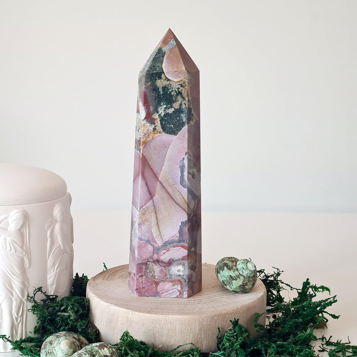 Tall polished crystal tower with purple, green and pale bands on a round display base.