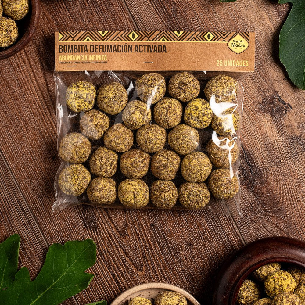 Clear packet of round botanical incense bombs with a gold Sagrada Madre label, displayed on a wooden surface.