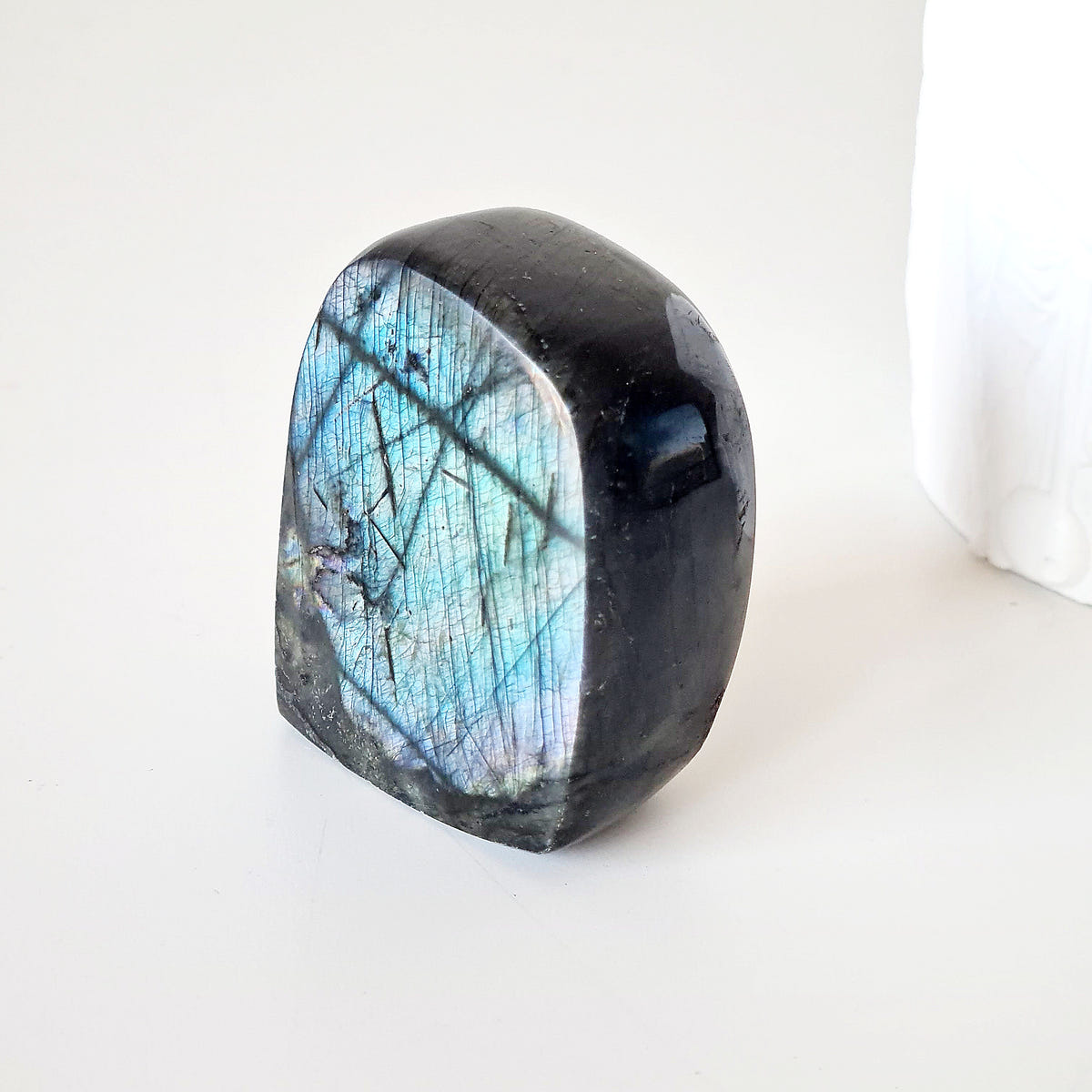 Labradorite freeform H with a rounded top and a blue face crossed by dark natural lines.