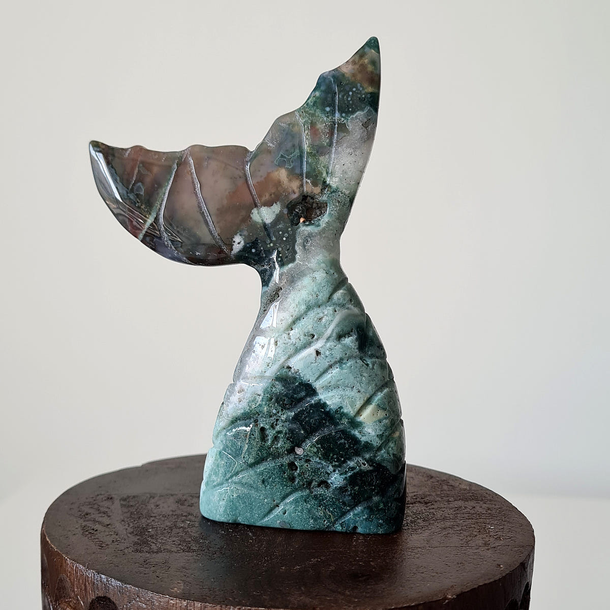 Ocean jasper mermaid tail C with dark green, grey and brown sections and curved fins.