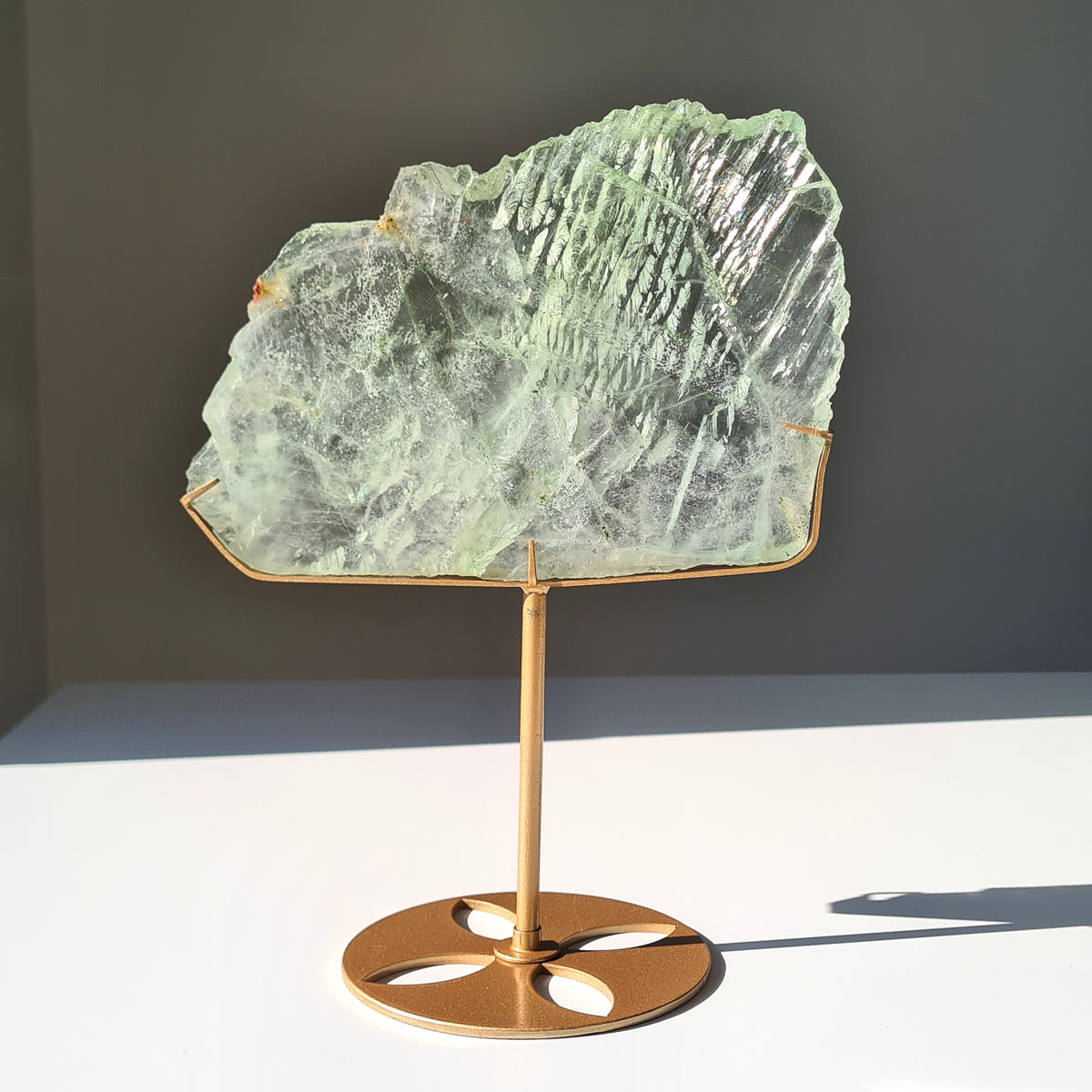 Fluorite Dream Portal W, a broad pale green slab with a ridged upper edge on a gold-coloured stand.