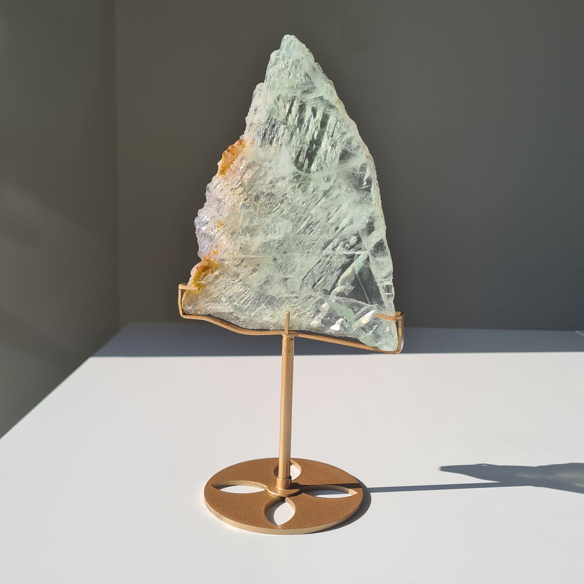 Fluorite Dream Portal V, a pointed pale green slab with white textured markings on a gold-coloured stand.