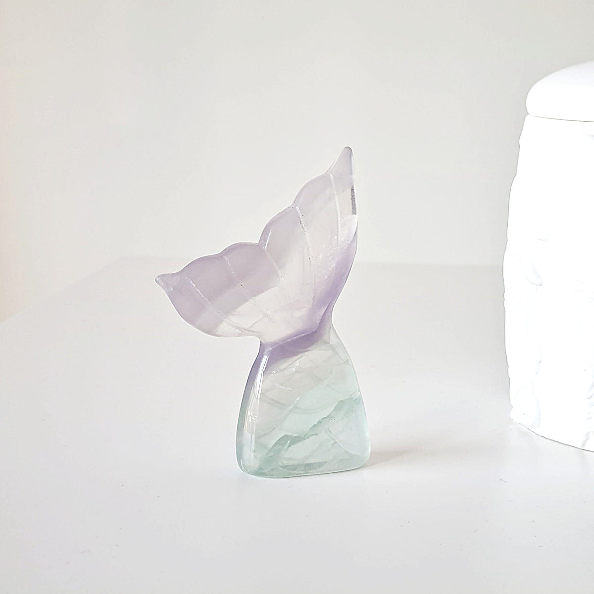 Lilac fluorite mermaid tail G with pale lavender fins and a translucent mint-green base.
