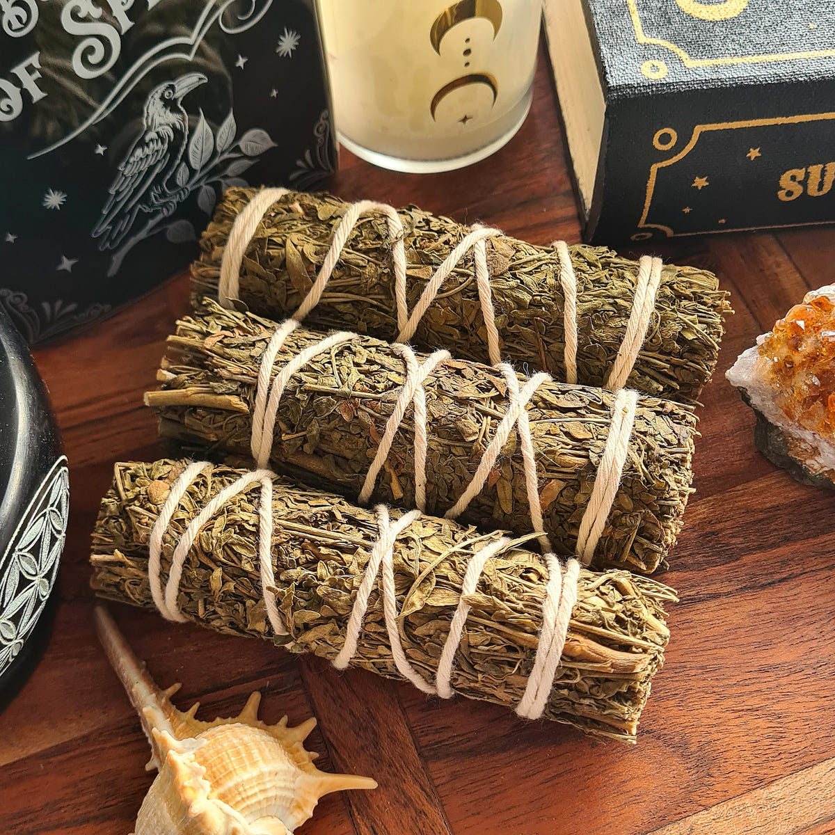 Three Rue smudge bundles tied with white string.