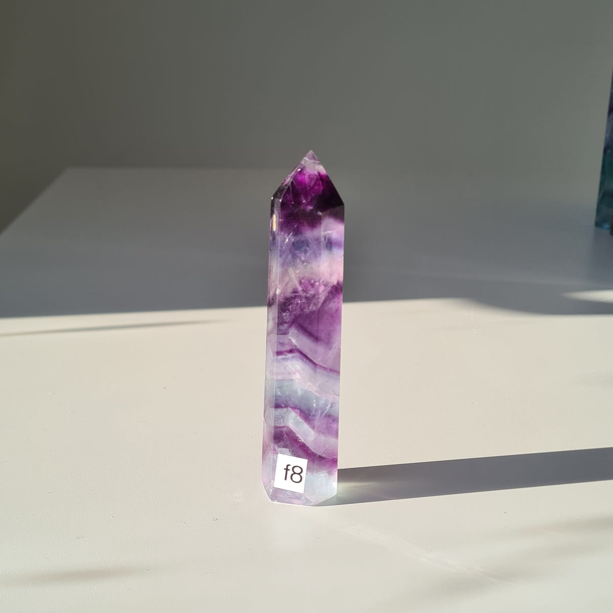 Dreamland fluorite point f8 with purple and pale lavender bands and a small numbered label.