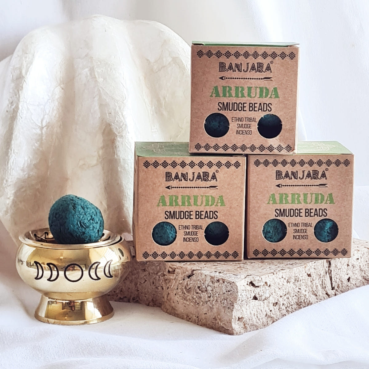 Banjara Arruda smudge bead boxes beside a teal incense bead in a brass-coloured bowl.