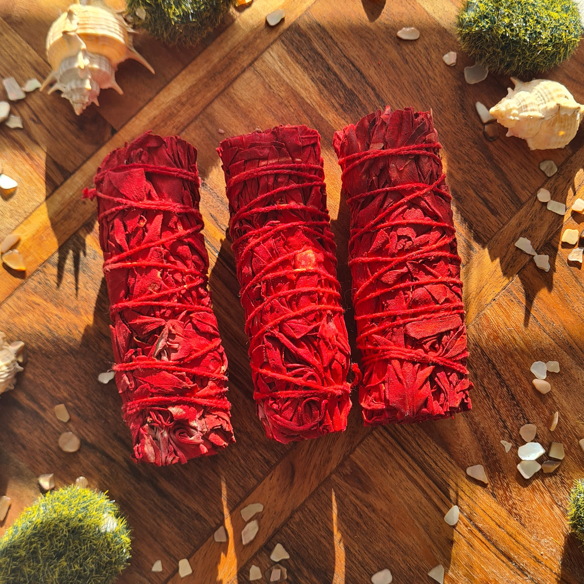 Red resin-coated sage bundles displayed together.