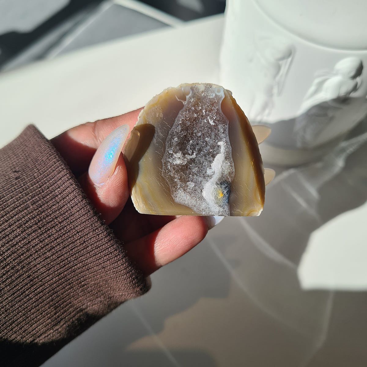 Small Agate geode with honey-brown edges and an elongated sparkling crystal centre.