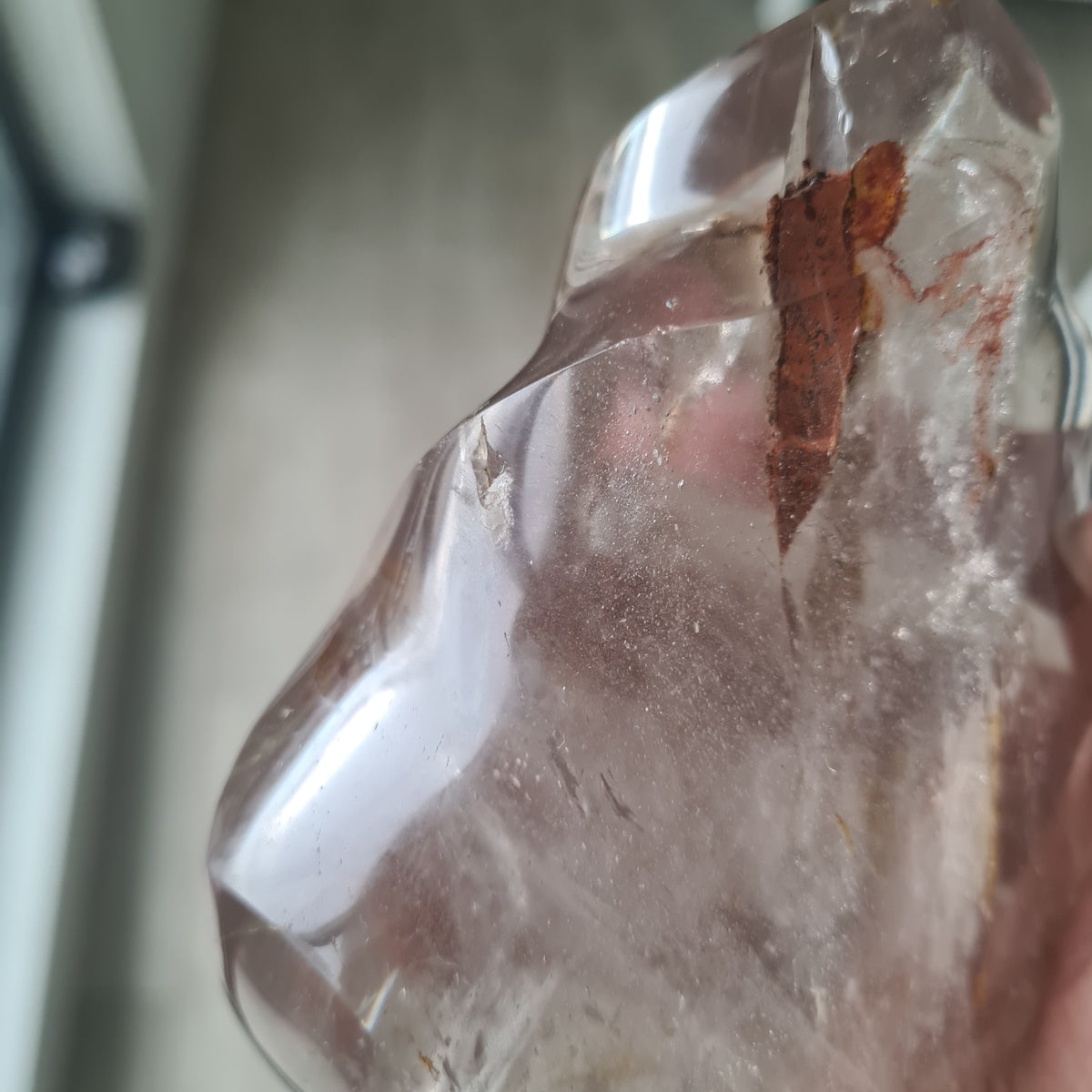 Close view of an open pocket and brown inclusions in a polished quartz flame.